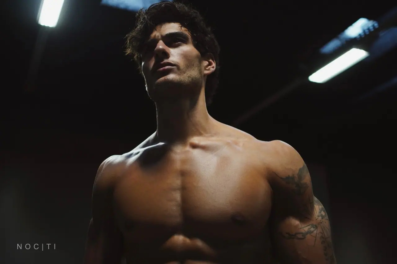 Adult male model under dark cinematic lights for a NOCTI Halloween men’s body-care guide