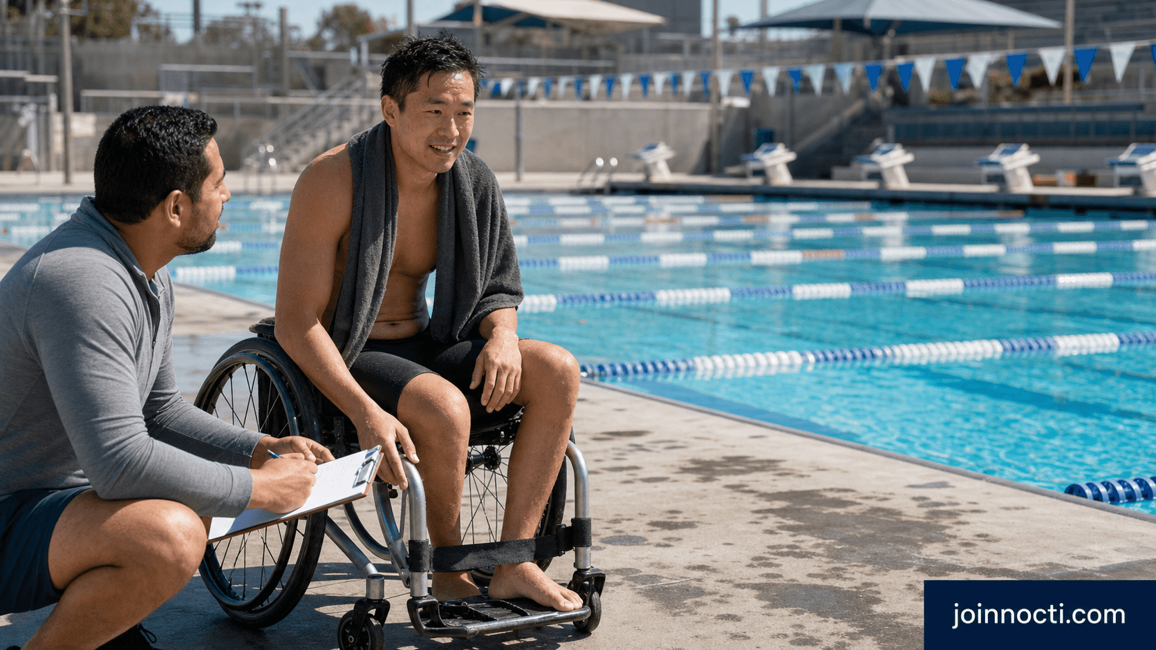 A male para swimmer using a sports wheelchair talks with a recovery professional beside an outdoor lap pool