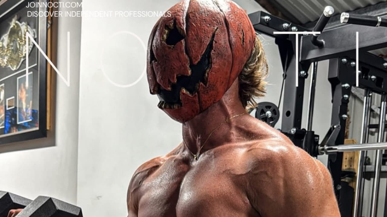 Adult male model wearing a pumpkin costume mask and holding a dumbbell in a NOCTI Halloween fitness image