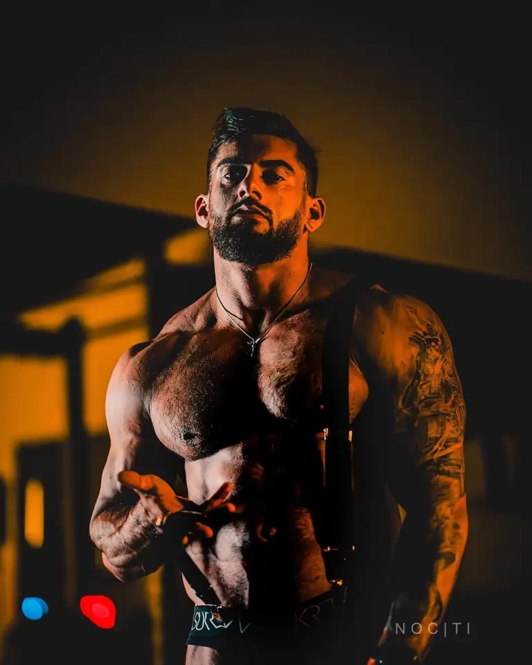 Adult male model under dramatic amber light illustrating a comparison of deep-tissue and relaxation massage